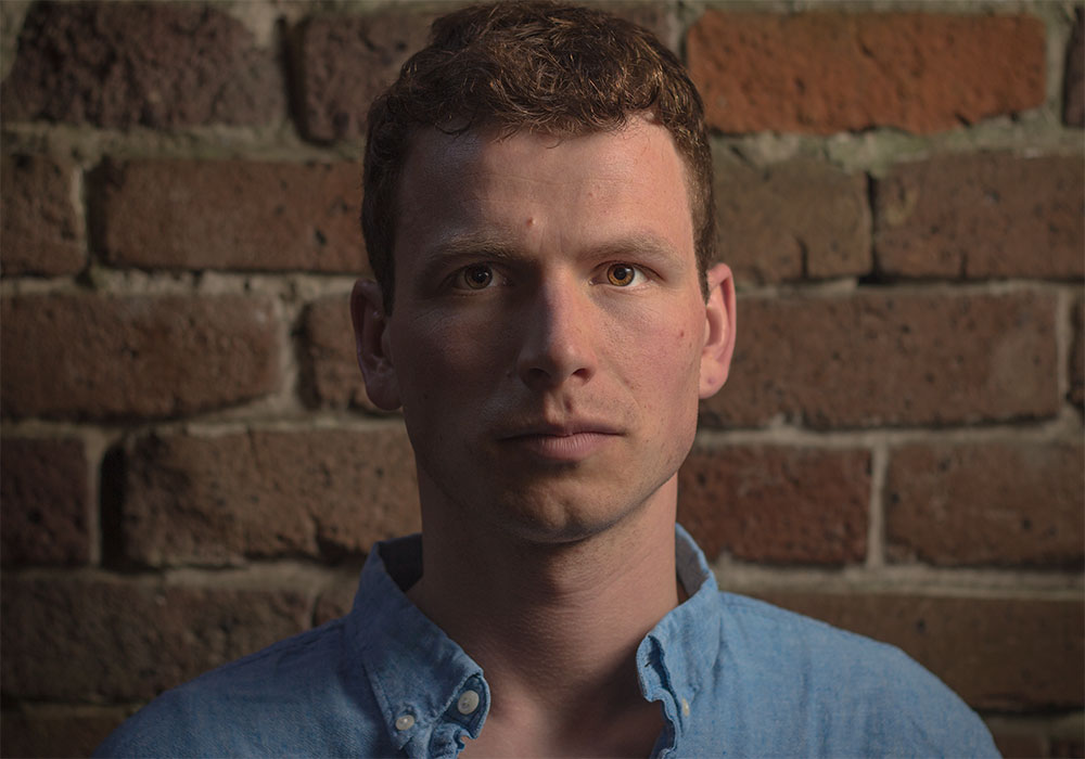 Before Edit-Photograph of a man in front of a brick background